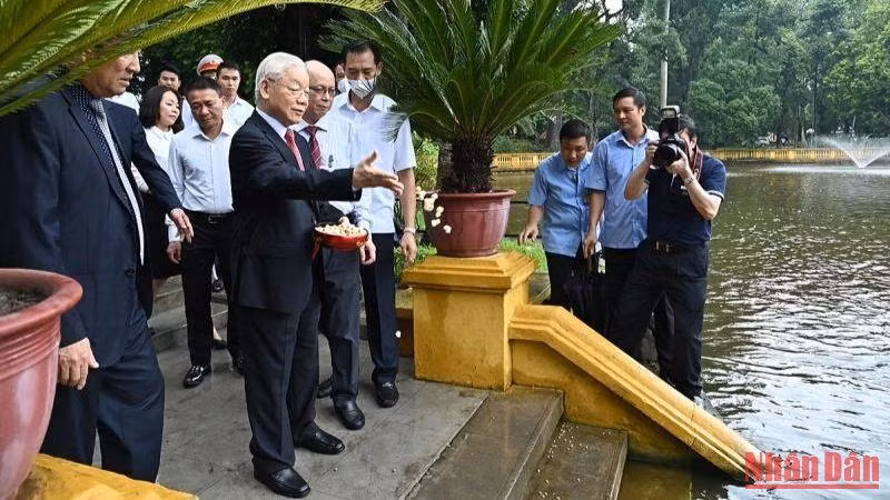 Tổng Bí thư Nguyễn Phú Trọng cho cá ăn tại ao cá Bác Hồ trong Khu Di tích Chủ tịch Hồ Chí Minh tại Phủ Chủ tịch. (Ảnh: Thủy Nguyên)