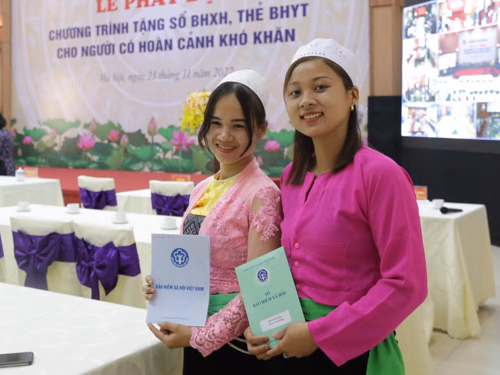 Chị Bùi Thị Hằng - tỉnh Hòa Bình (bên phải) cho biết: sau khi được tặng sổ bảo hiểm xã hội tự nguyện sẽ cố gắng tiếp tục tham gia vào những năm sau.