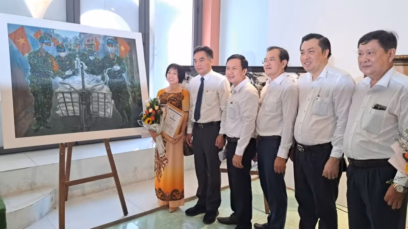 Các đại biểu chụp hình lưu niệm với tác giả Phạm Thị Hồng Xuyến có tác phẩm “Cuộc chiến không tiếng súng” đoạt giải Nhì cuộc thi.