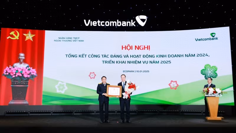 Đại diện Vietcombank, đồng chí Lê Quang Vinh, Ủy viên Ban Thường vụ Đảng ủy, Phó Tổng Giám đốc phụ trách Ban Điều hành nhận Bằng khen của Tổng Cục Thuế. Đại diện Vietcombank, đồng chí Lê Quang Vinh, Ủy viên Ban Thường vụ Đảng ủy, Phó Tổng Giám đốc phụ trách Ban Điều hành nhận Bằng khen của Tổng Cục Thuế.