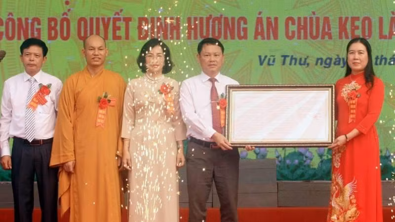 Thừa ủy quyền của Thủ tướng Chính phủ, bà Trần Thị Bích Hằng, Phó Chủ tịch Ủy ban nhân dân tỉnh Thái Bình (bên phải) trao Quyết định của Thủ tướng Chính phủ công nhận Hương án chùa Keo là bảo vật quốc gia.