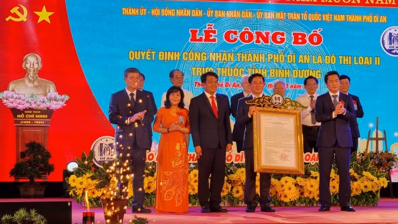 Thừa ủy nhiệm Thủ tướng Chính phủ, Thứ trưởng Xây dựng Nguyễn Tường Văn (phải) trao Quyết định công nhận thành phố Dĩ An là đô thị loại II cho lãnh đạo thành phố Dĩ An. 