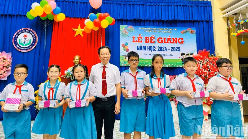 Thầy Trần Văn Sơn, Hiệu trưởng Trường tiểu học Kim Đồng (thành phố Bạc Liêu), trao phần thưởng cho các học sinh có thành tích xuất sắc, năm học 2024-2025. (Ảnh: TRỌNG DUY)