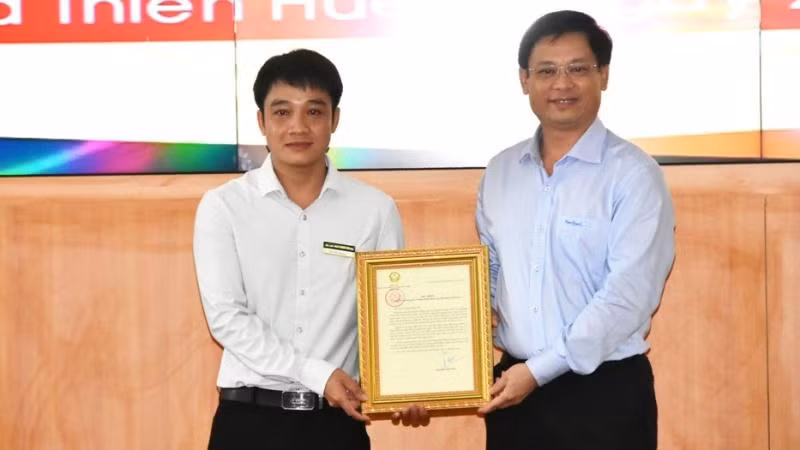 Phó Chủ tịch Thường trực UBND tỉnh Thừa Thiên Huế Nguyễn Thanh Bình (bên phải) trao Thư khen của Chủ tịch nước cho anh Tô Vũ Đồng.