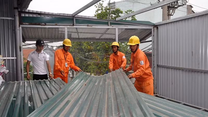 Tổng Công ty Điện lực Hà Nội hỗ trợ tháo dỡ công trình vi phạm. Ảnh: Hoa Việt Cường