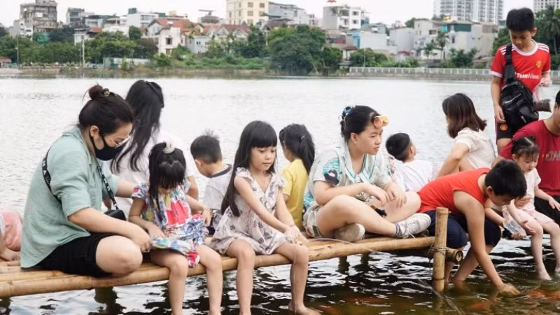 Các bạn nhỏ là những người thích thú nhất với sự xuất hiện của đàn cá Koi ở Hồ Tây.