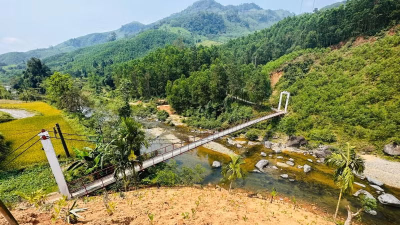 Đồi đất thải cao hơn cầu treo Nước Lô, nguy cơ cuốn trôi cầu khi mưa lũ về.