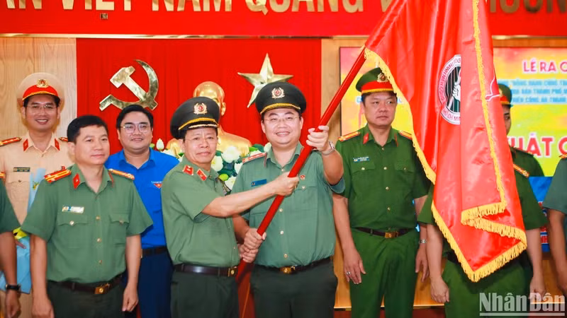 Lãnh đạo Công an thành phố trao cờ cho tuổi trẻ Công an Thành phố trong lễ ra mắt công trình thanh niên.