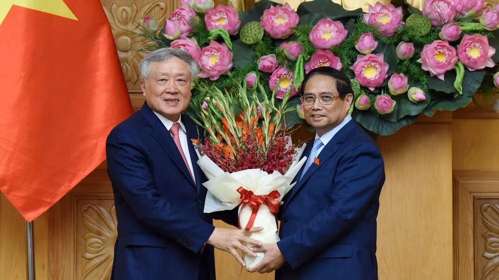 Thủ tướng Phạm Minh Chính tặng hoa chúc mừng Phó Thủ tướng Chính phủ Nguyễn Hòa Bình. (Ảnh: TRẦN HẢI)