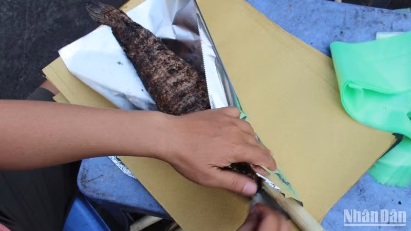Cá lóc nướng được người bán gói cẩn thận bằng giấy bạc.