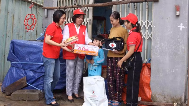 Các tình nguyện viên Hội Chữ thập đỏ trao túi sơ cứu, túi hàng cho hộ thuê trọ.