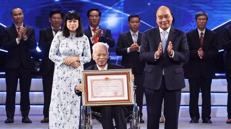 Chủ tịch nước Nguyễn Xuân Phúc trao Giải thưởng Hồ Chí Minh cho Giáo sư, Tiến sĩ khoa học Nguyễn Quang Hồng, tác giả công trình "Tự điển chữ Nôm dẫn giải". (Ảnh: Thống Nhất/TTXVN)