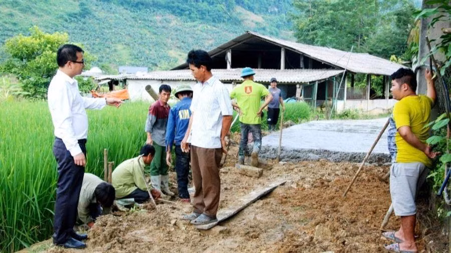Bí thư Đảng ủy thị trấn Phong Hải Vũ Trung Dũng (áo trắng, bìa trái) kiểm tra đổ bê tông đường giao thông đến hộ gia đình ở thôn Ải Nam, chủ yếu là đồng bào dân tộc thiểu số sinh sống.