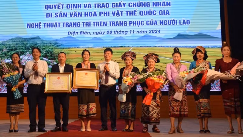 Đồng chí Nguyễn Thái Bình, Chủ tịch Ủy ban nhân dân huyện Điện Biên và đại diện lãnh đạo Sở Văn hóa, Thể thao và Du lịch Điện Biên trao Bằng công nhận Di sản văn hóa phi vật thể quốc gia Nghệ thuật trang trí trên trang phục của người Lào, cho cộng đồng dân tộc Lào ở hai huyện: Điện Biên và Điện Biên Đông.