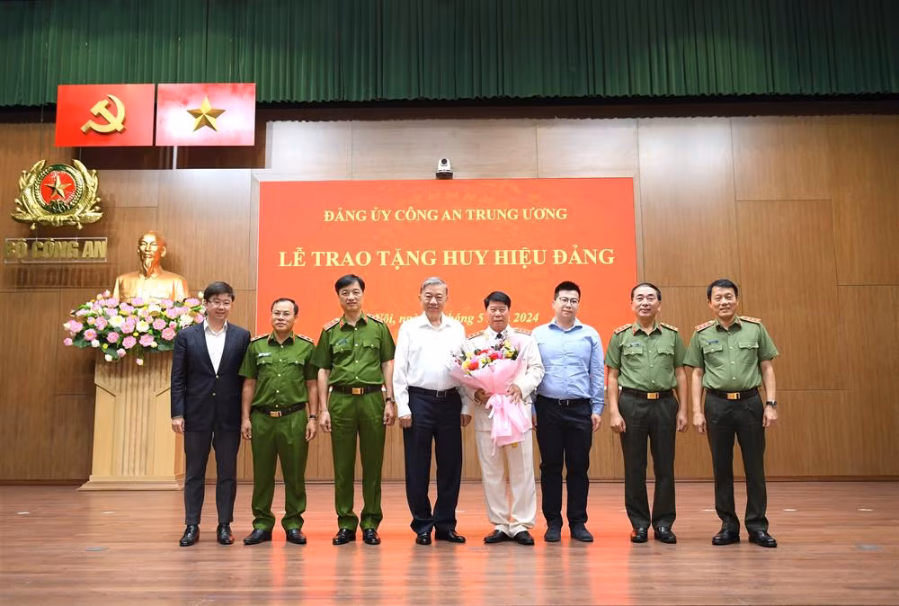 Chủ tịch nước Tô Lâm và các đồng chí trong Ban Thường vụ Đảng ủy Công an Trung ương, lãnh đạo Bộ Công an chụp ảnh lưu niệm cùng đồng chí Bùi Văn Nam và thân nhân gia đình đồng chí. (Ảnh: Bộ Công an)