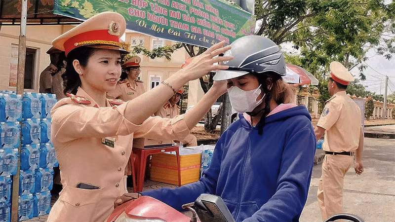 Lực lượng Cảnh sát giao thông Công an tỉnh Đắk Nông trao mũ bảo hiểm tặng người dân trên đường về quê đón Tết.