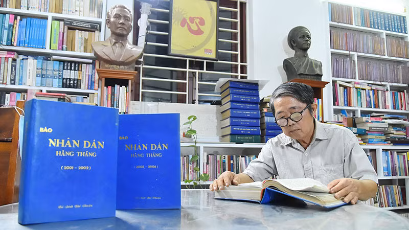 Nhà báo Mai Sông Bé với các số báo Nhân Dân hằng tháng mà ông đã dày công sưu tầm và đóng thành quyển để lưu giữ.