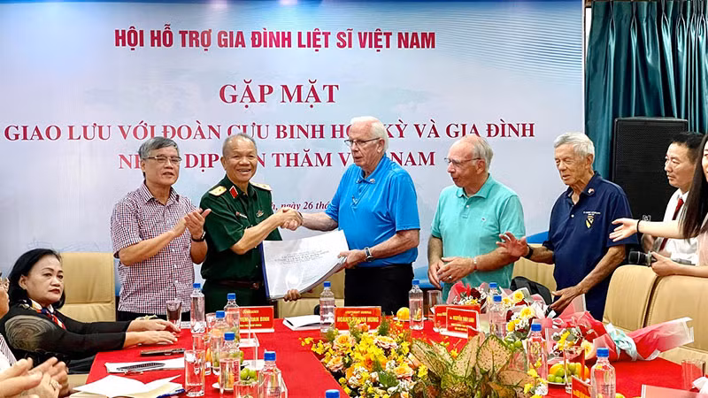 Cựu chiến binh Mỹ Bob Connor (thứ 3 từ trái sang) trao hồ sơ thông tin mộ liệt sĩ cho Trung tướng Hoàng Khánh Hưng, Chủ tịch Hội Hỗ trợ gia đình liệt sĩ Việt Nam.