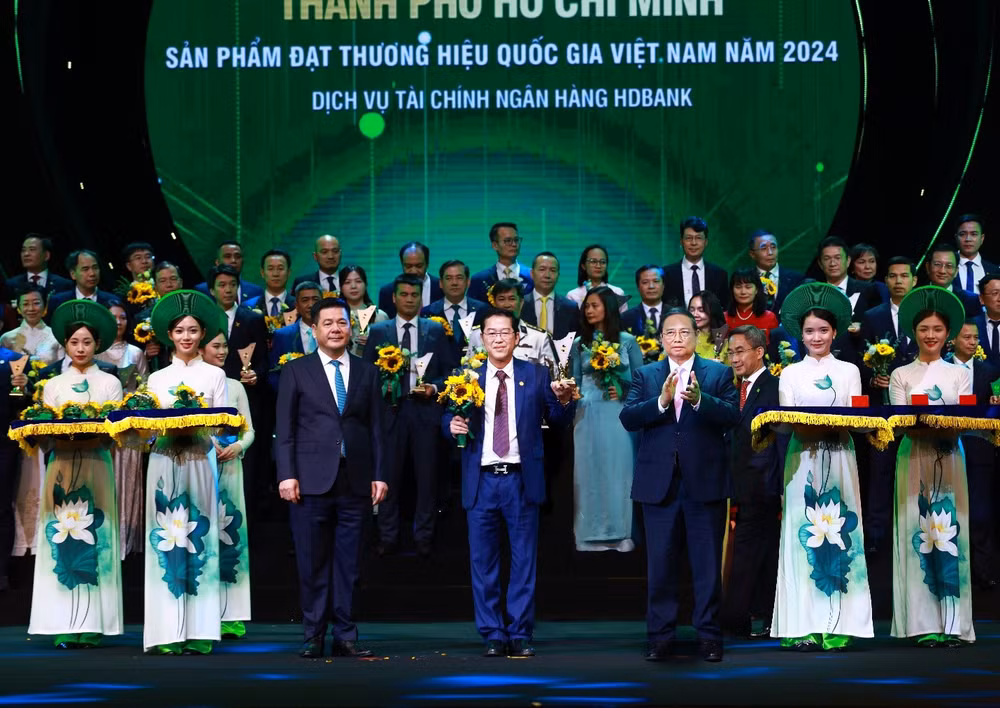 Tổng Giám đốc HDBank Phạm Quốc Thanh nhận biểu trưng Thương hiệu Quốc gia Việt Nam 2024 từ Thủ tướng Chính phủ Phạm Minh Chính và hoa chúc mừng từ Bộ trưởng Công thương Nguyễn Hồng Diên với những đóng góp của HDBank cho thị trường tài chính và sự phát triển kinh tế Việt Nam.