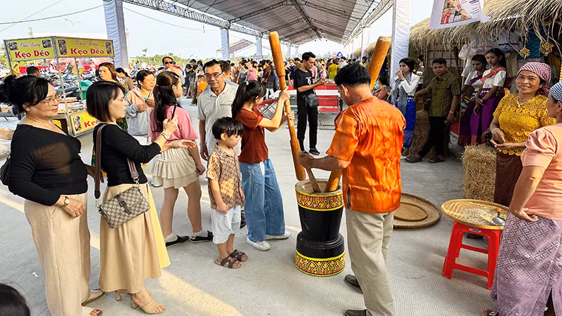 Du khách trải nghiệm làm cốm dẹp với đồng bào Khmer Sóc Trăng.