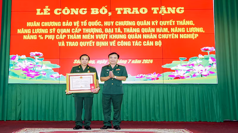 Đại tá Nguyễn Trìu Mến trao Huân chương Bảo vệ Tổ quốc hạng Nhì cho Đại tá Vũ Công Đạo.