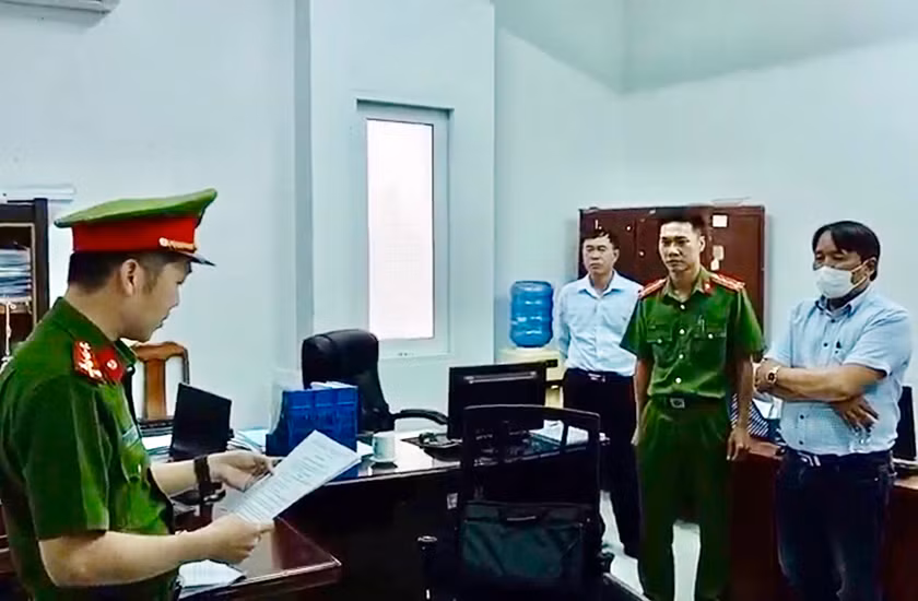 Trần Hữu Dũng (khoanh tay) nghe lệnh bắt bị can từ cơ quan chức năng.