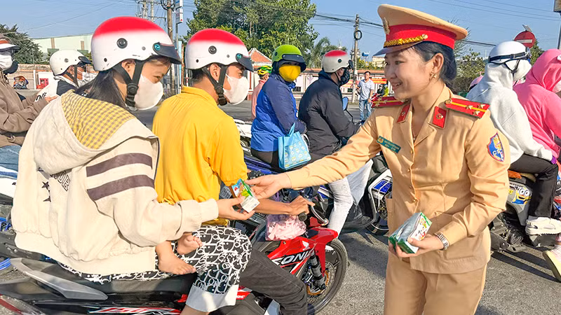 Lực lượng cảnh sát giao thông Công an tỉnh Vĩnh Long tặng nước suối và sữa cho người đi đường