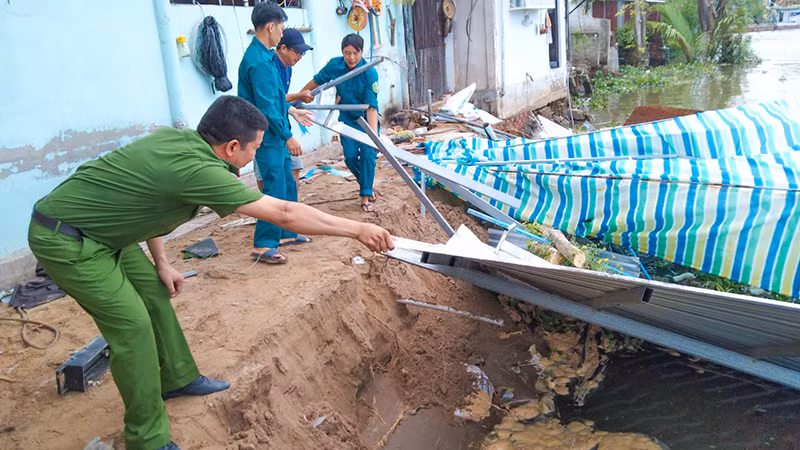 Lực lượng chức năng xã Tân An Luông đến hỗ trợ người dân di dời tài sản. 