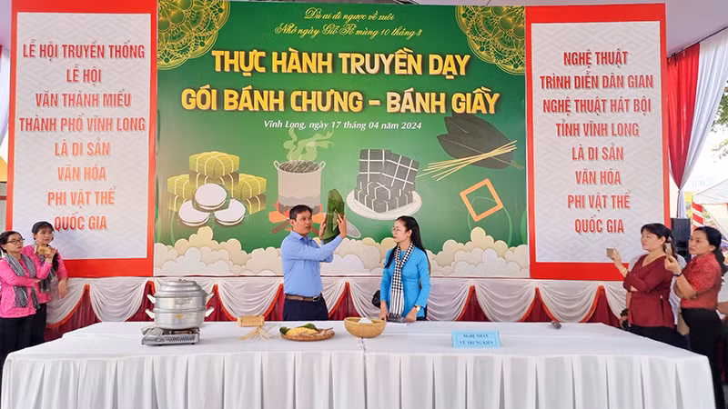 Nghệ nhân Vũ Trung Kiên, giảng viên Trường đại học Sư phạm Kỹ thuật Vĩnh Long hướng dẫn thực hành gói bánh, bánh giày.