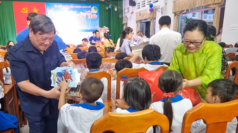 Đồng chí Trần Văn Rón và Phó Chủ tịch Ủy ban nhân dân tỉnh Vĩnh Long Nguyễn Thị Quyên Thanh trao quà trung thu cho các em thiếu nhi. 