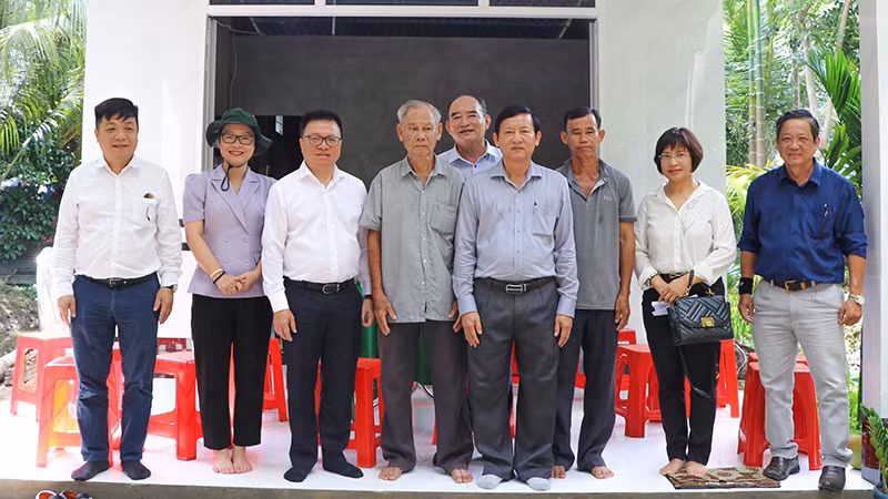 Tổng Biên tập Báo Nhân Dân Lê Quốc Minh cùng đoàn công tác thăm nhà và chụp hình lưu niệm.
