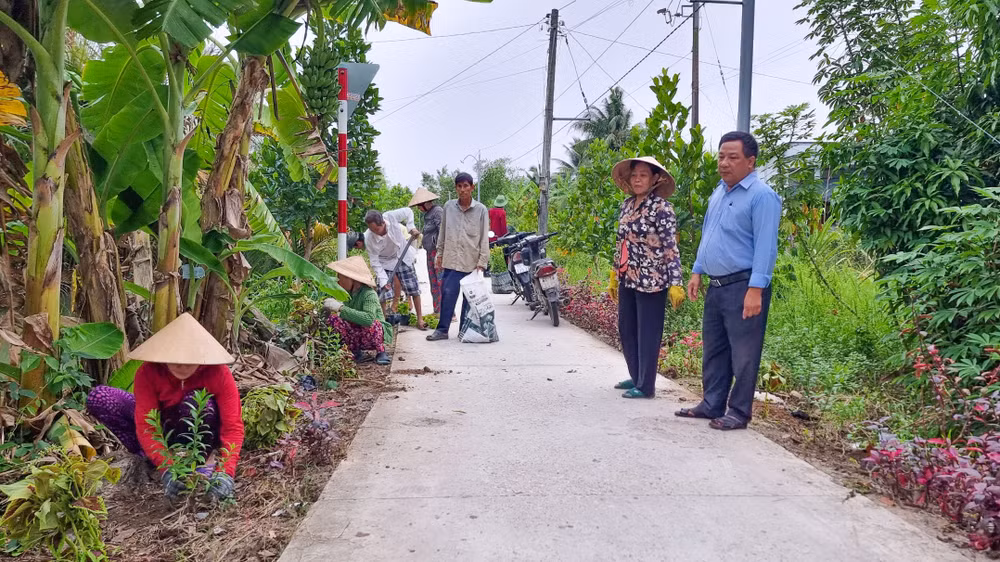 Những cô chú ấp Mỹ Phú tham gia trồng hoa trên tuyến đường giao thông nông thôn ở địa phương. 