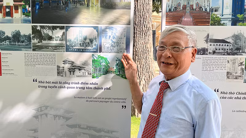 Bác Phạm Tuệ, người có nhiều bộ sưu tập về di sản kiến trúc Pháp tại Hải Phòng bên bức ảnh là chân dung của ông lúc nhỏ khi sống ở Hải Phòng được trưng bày tại triển lãm.
