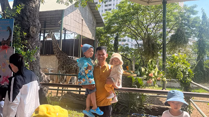 Du khách thích thú chụp ảnh lưu niệm với gia đình hươu cao cổ.