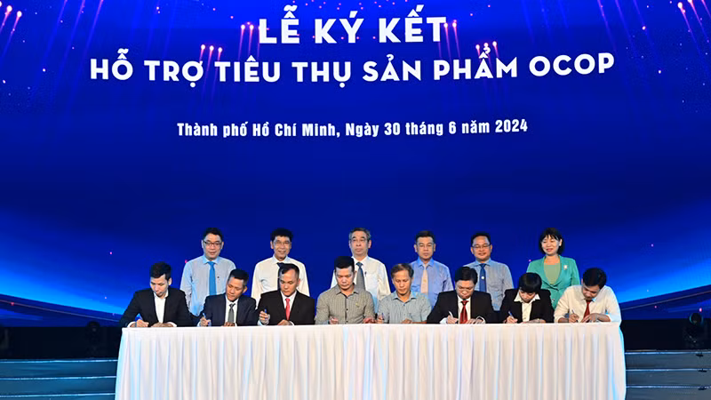 Các đơn vị thực hiện lễ ký kết hỗ trợ tiêu thụ sản phẩm OCOP tại chương trình. (Ảnh: Quốc Thanh)