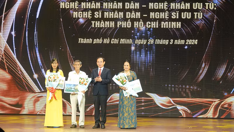 Đồng chí Nguyễn Văn Nên, Ủy viên Bộ Chính trị, Bí thư Thành ủy Thành phố Hồ Chí Minh tặng hoa, quà chúc mừng các Nghệ nhân Nhân dân.