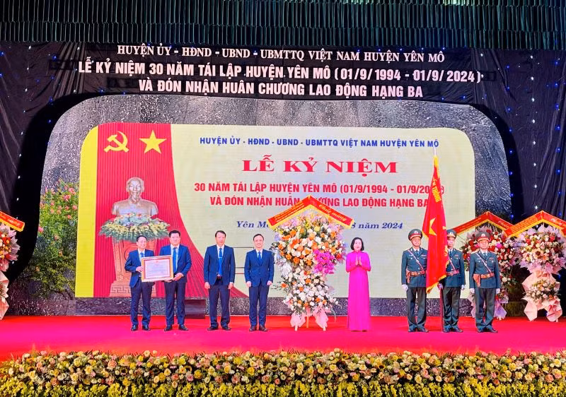 Đồng chí Nguyễn Thị Thanh, Ủy viên Trung ương Đảng, Phó Chủ tịch Quốc hội trao Huân chương Lao động và tặng hoa chúc mừng tại lễ kỷ niệm. (Ảnh: Yến Trinh)