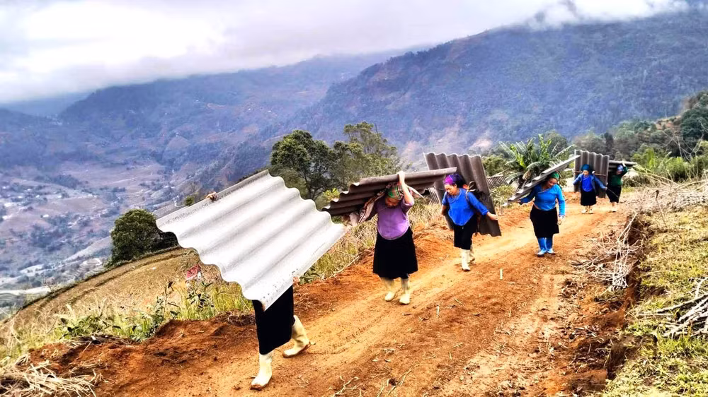 Hội viên phụ nữ tỉnh Hà Giang giúp công lao động vận chuyển vật liệu xóa nhà tạm cho hộ nghèo.
