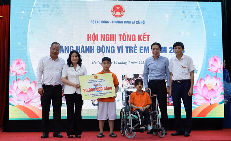 Thứ trưởng Nguyễn Thị Hà tặng quà cho trẻ em tại Trung tâm Phục hồi chức năng người khuyết tật Thụy An. (Ảnh: Molisa) 