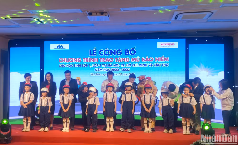 Đại diện ban tổ chức tặng mũ cho các học sinh lớp 1 và lớp 2 tại lễ công bố chương trình.