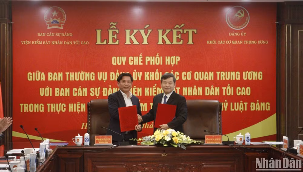 Các đồng chí Ủy viên Trung ương Đảng: Nguyễn Văn Thể và Lê Minh Trí ký kết văn bản phối hợp công tác.