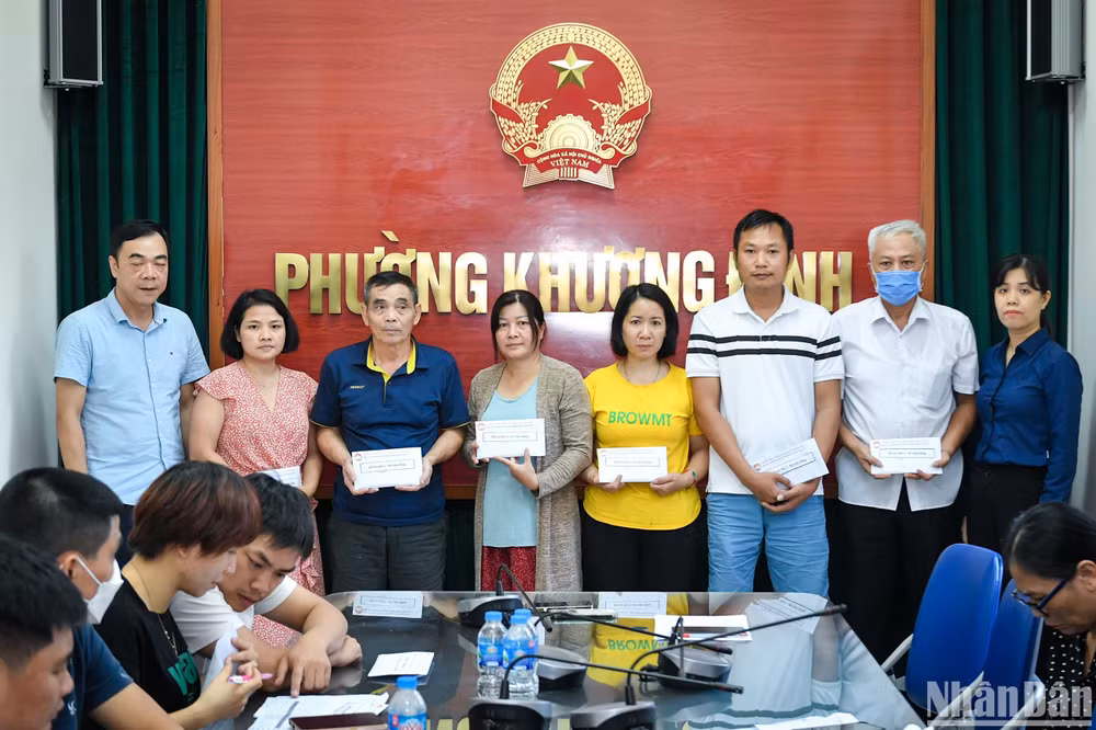 Các nạn nhân bị ảnh hưởng bởi vụ cháy nhận tiền hỗ trợ tại Ủy ban nhân dân phường Khương Đình chiều 15/9. (Ảnh: THÀNH ĐẠT)