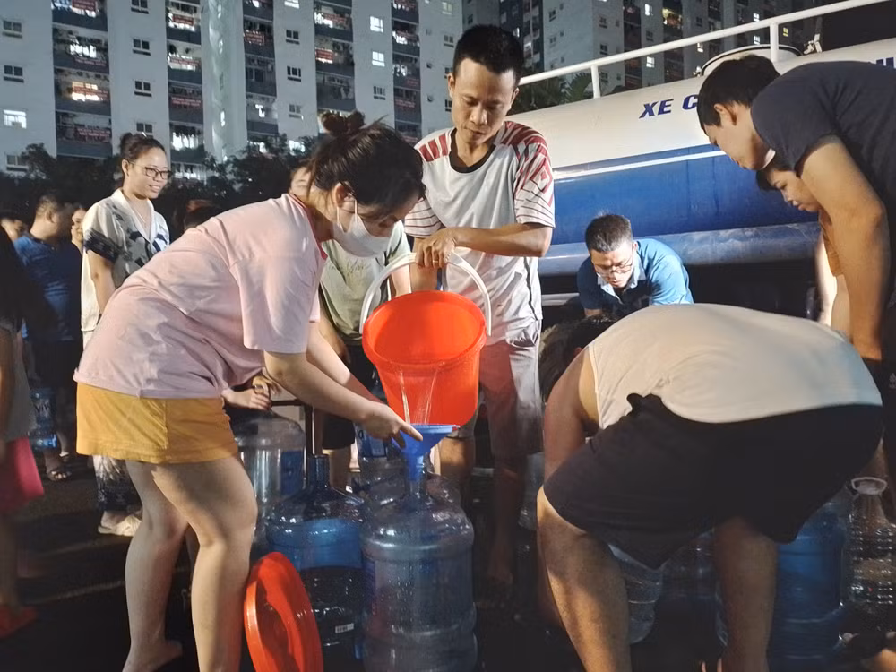 Người dân hứng từng xô nước sạch về sử dụng. (Ảnh chụp lúc 21 giờ tối 24/10)
