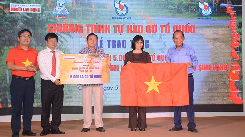 Ông Trương Hòa Bình, nguyên Ủy viên Bộ Chính trị, nguyên Phó Thủ tướng Thường trực Chính phủ (ngoài cùng bên phải); ông Trần Trọng Dũng, Phó Chủ tịch Hội Nhà báo Việt Nam phụ trách phía Nam và ông Lê Cao Cường, Phó Tổng Biên tập Báo Người Lao Động, tặng cờ cho đồng bào, chiến sĩ tỉnh Gia Lai.