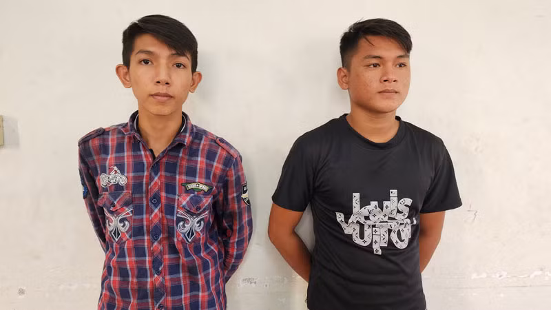 Công an đọc quyết định bắt tạm giam Nguyễn Minh Tâm (bên trái) và Trần Thanh Trọng. 