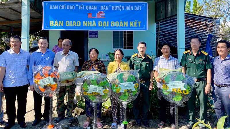 Ban Chỉ đạo các hoạt động “Tết quân-dân” huyện Hòn Đất và các nhà hảo tâm trao các phần quà và tiền mặt cho các gia đình nhận nhà Đại đoàn kết.