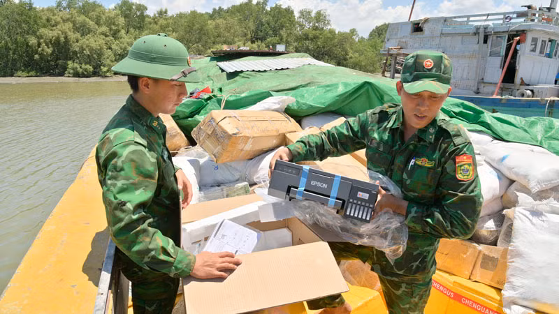 Cán bộ, chiến sĩ Đồn Biên phòng Lình Huỳnh kiểm tra hàng hóa dưới tàu. (Ảnh: TIẾN VINH)