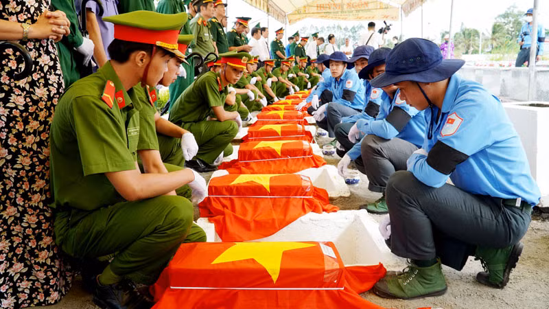 Cán bộ, chiến sĩ và nhân dân tỉnh Kiên Giang thực hiện nghi thức an táng hài cốt liệt sĩ, ngày 27/7.