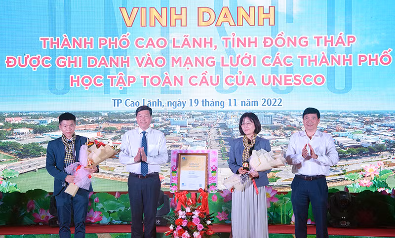 Bà Miki Nozawa, Trưởng Ban Giáo dục Văn phòng UNESCO tại Hà Nội trao chứng nhận cho thành phố Cao Lãnh và nhận biểu trưng, hoa do tỉnh Đồng Tháp trao tặng.