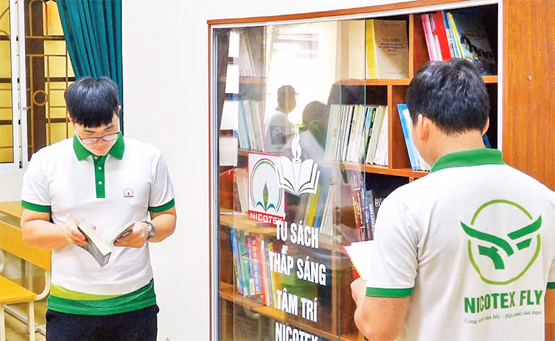 Công nhân lao động sử dụng phòng đọc sách tại điểm sinh hoạt văn hóa công nhân ở Công ty Cổ phần Nicotex, quận Long Biên. (Ảnh ĐỖ PHƯỢNG)